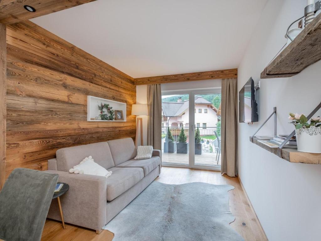 sala de estar con sofá y ventana grande en Ski Nature Apartment Lungau Top 8 en Mauterndorf