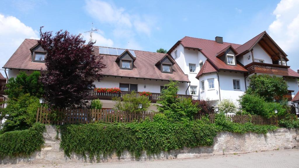uma grande casa branca com uma cerca em Hotel Gasthof Käßer em Ansbach