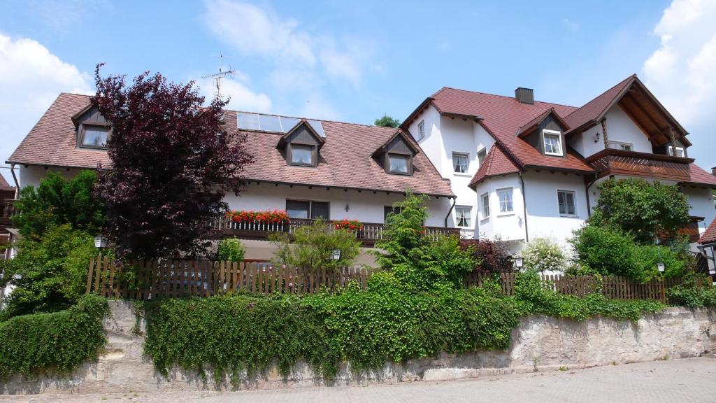 ein großes weißes Haus mit einem Zaun in der Unterkunft Hotel Gasthof Käßer in Ansbach