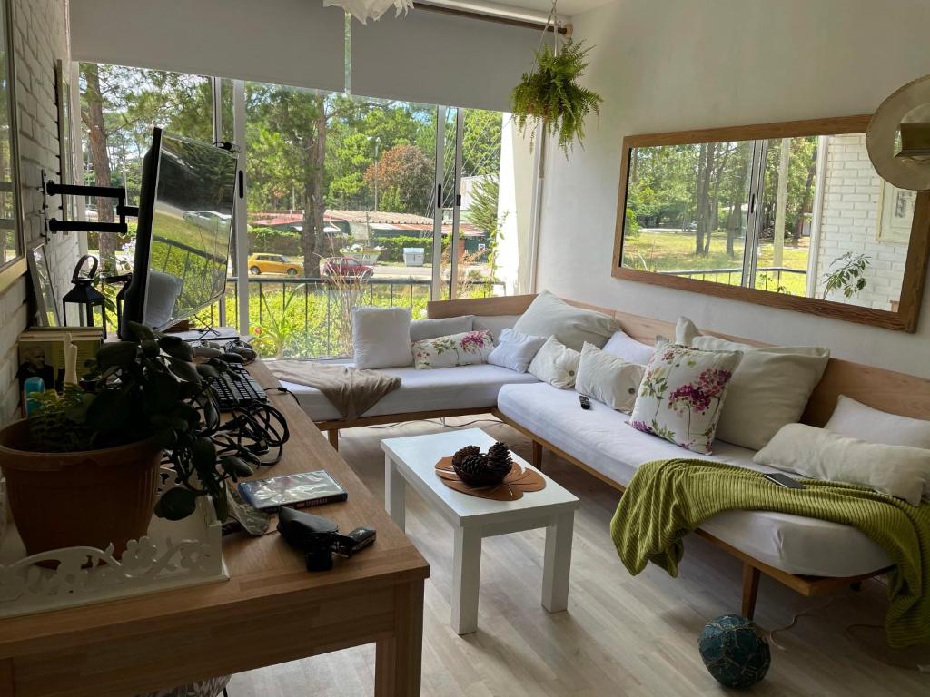 ein Wohnzimmer mit einem Sofa und einem Tisch in der Unterkunft Loft en cantegril in Punta del Este