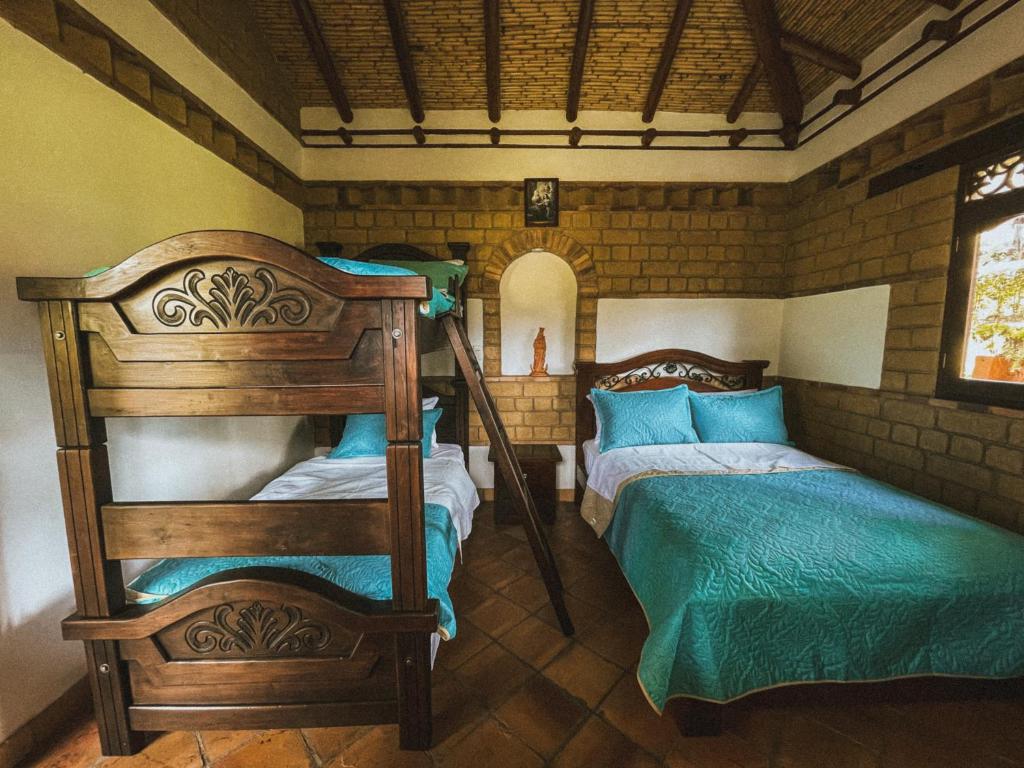 a bedroom with two bunk beds and a mirror at Posada María del Carmen in Ráquira