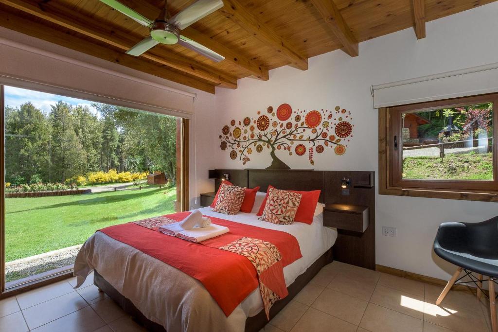 um quarto com uma cama e uma grande janela em Solar Selvana - Casas de montaña em Villa La Angostura