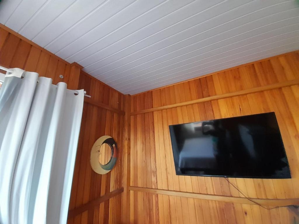 a corner of a room with a tv and a curtain at Casa centro Porto belo in Porto Belo