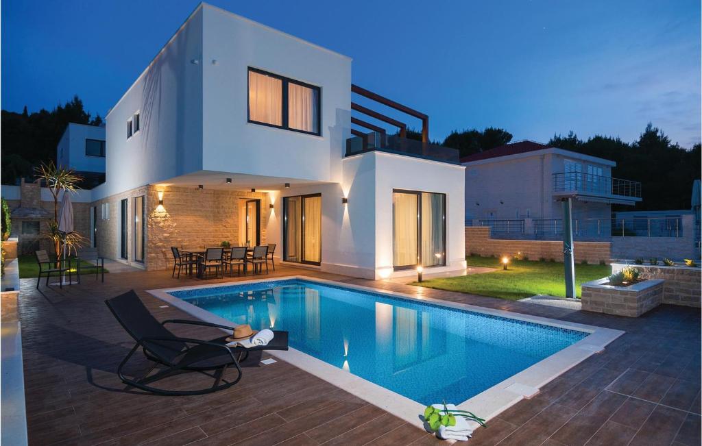 a house with a swimming pool in front of it at Amazing Home In Okrug Gornji With 6 Bedrooms, Indoor Swimming Pool And Outdoor Swimming Pool in Trogir