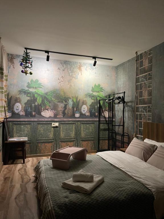 a bedroom with a large bed with a painting on the wall at kushki's home in Tbilisi City