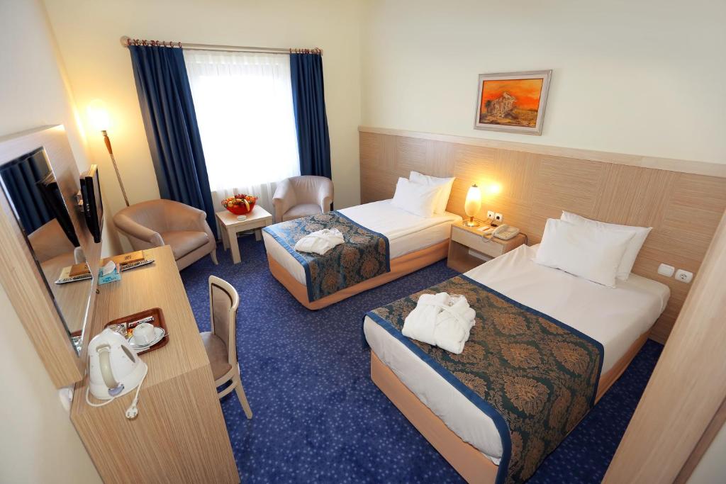 アンカラにあるキング ホテル カンカヤのベッド2台とデスクが備わるホテルルームです。