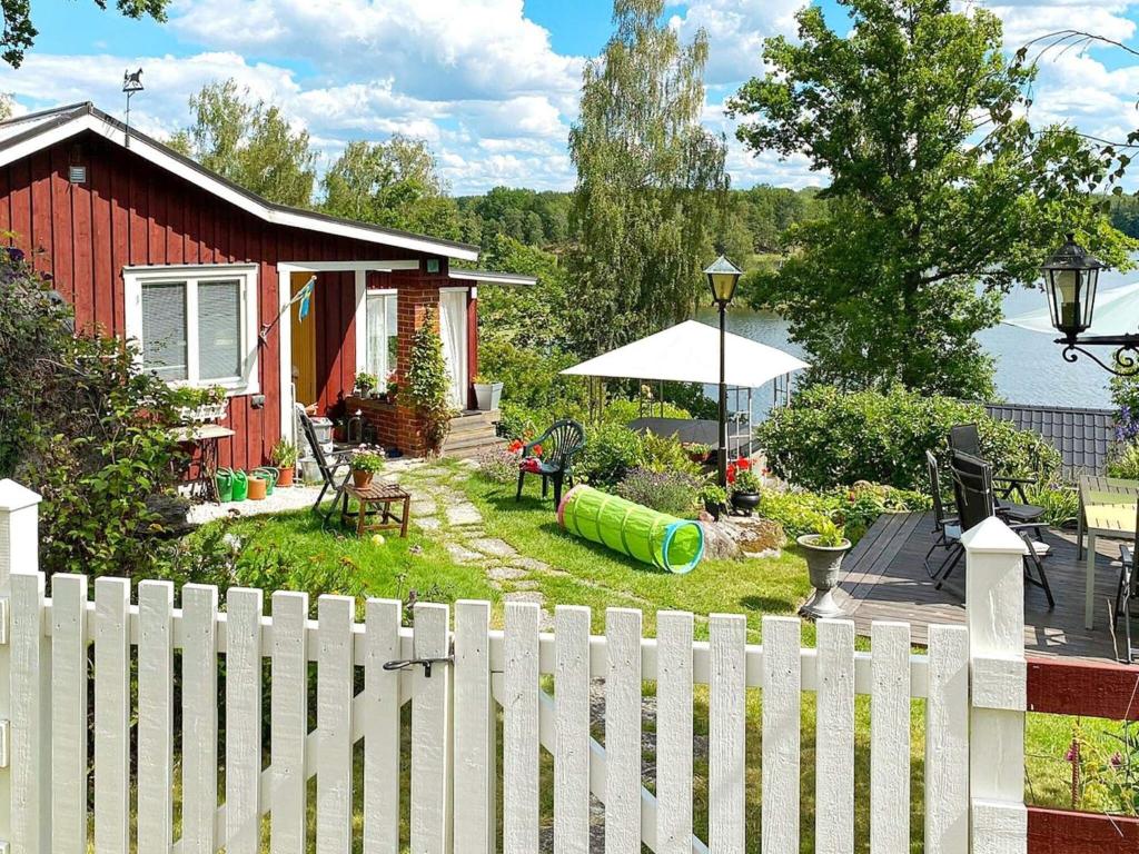 a white picket fence in front of a house at Holiday home LINKÖPING II in Linköping