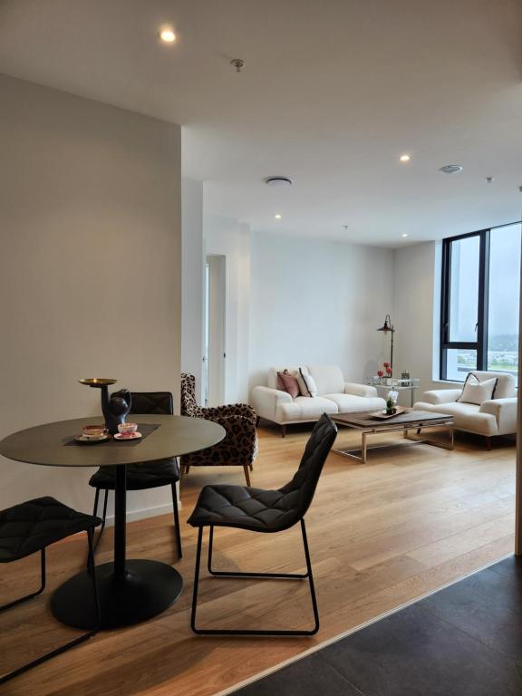 un soggiorno con tavolo, sedie e divano di Stay Max Apartment for Perfect Short Stay ad Auckland