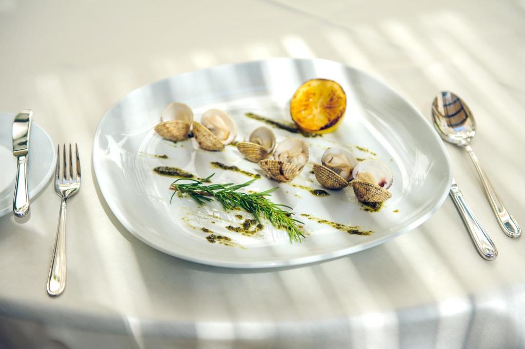 a plate of food on a table with silverware at Hotel Azimut in Sveti Stefan