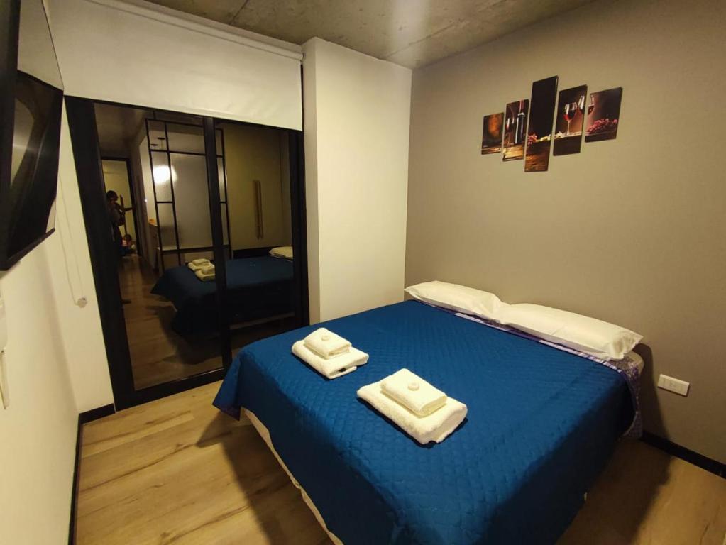 a room with a blue bed with two towels on it at Departamento - Salta Capital sm - Edificio Usina in Salta