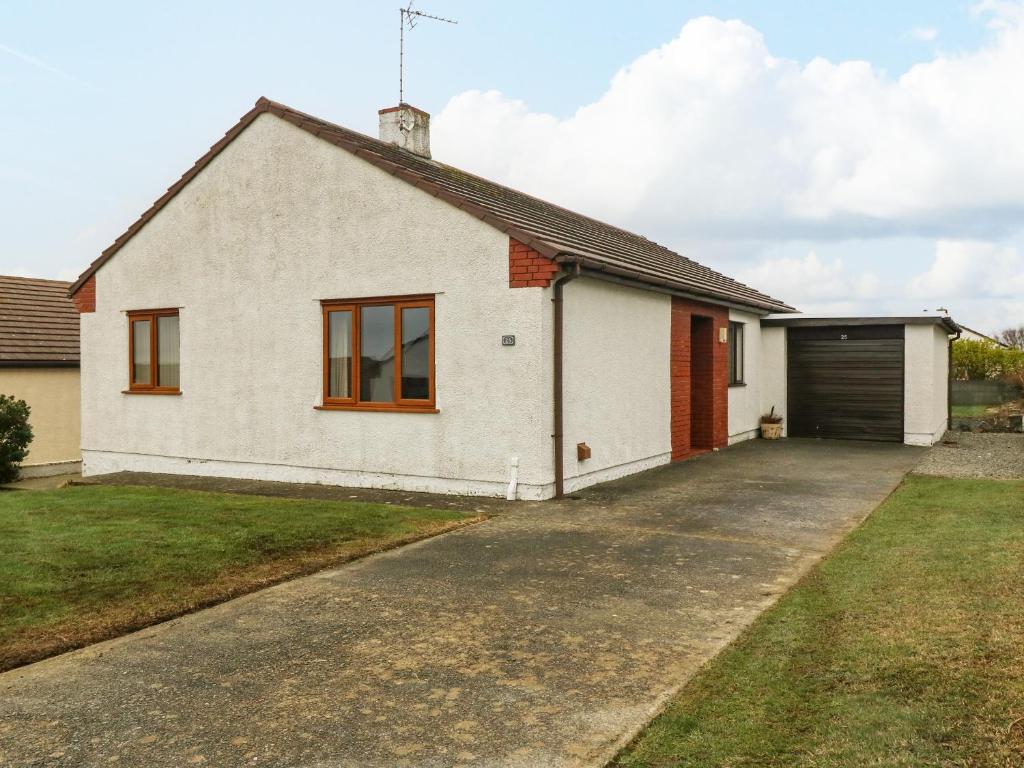 a detached house with a garage and a driveway at Arwelfa in Valley