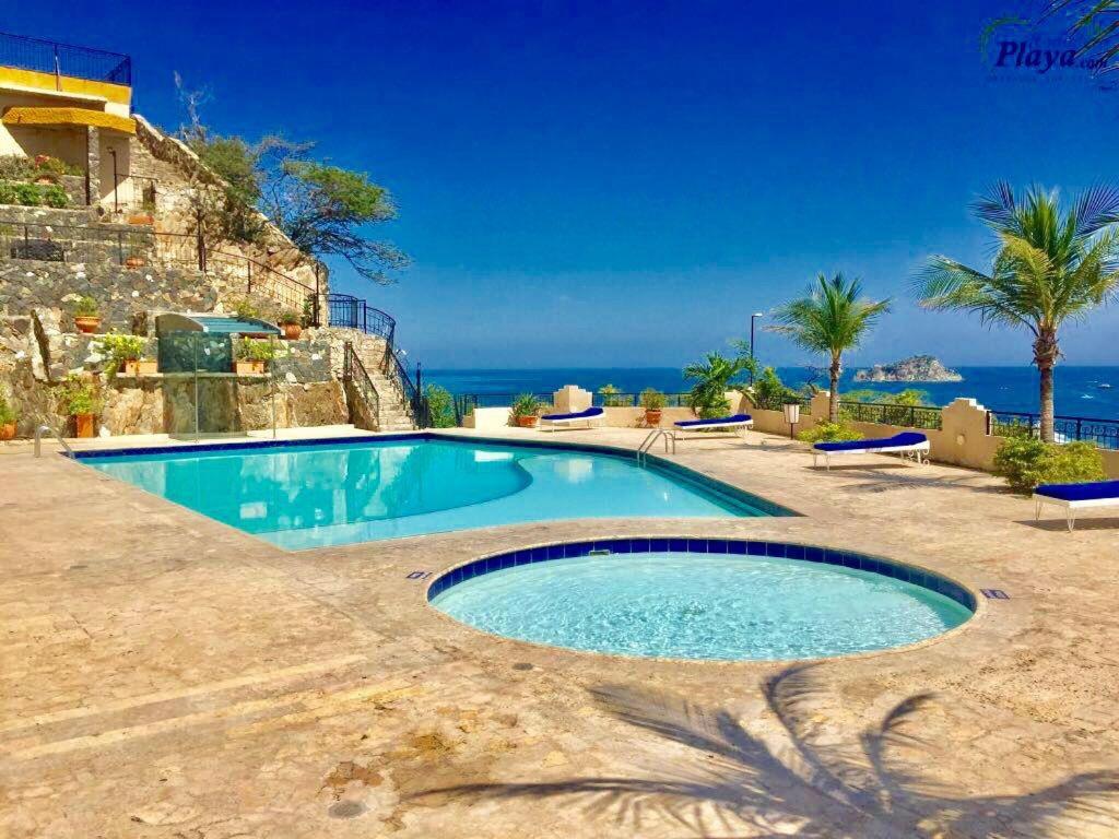a swimming pool with the ocean in the background at Apartamento Rodadero frente a la playa in Rodadero
