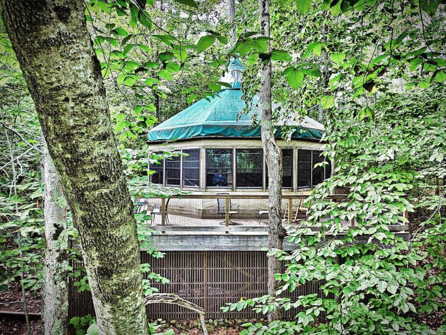 un edificio con techo verde en el bosque en Escape to Tree House Island Life, en Monmouth