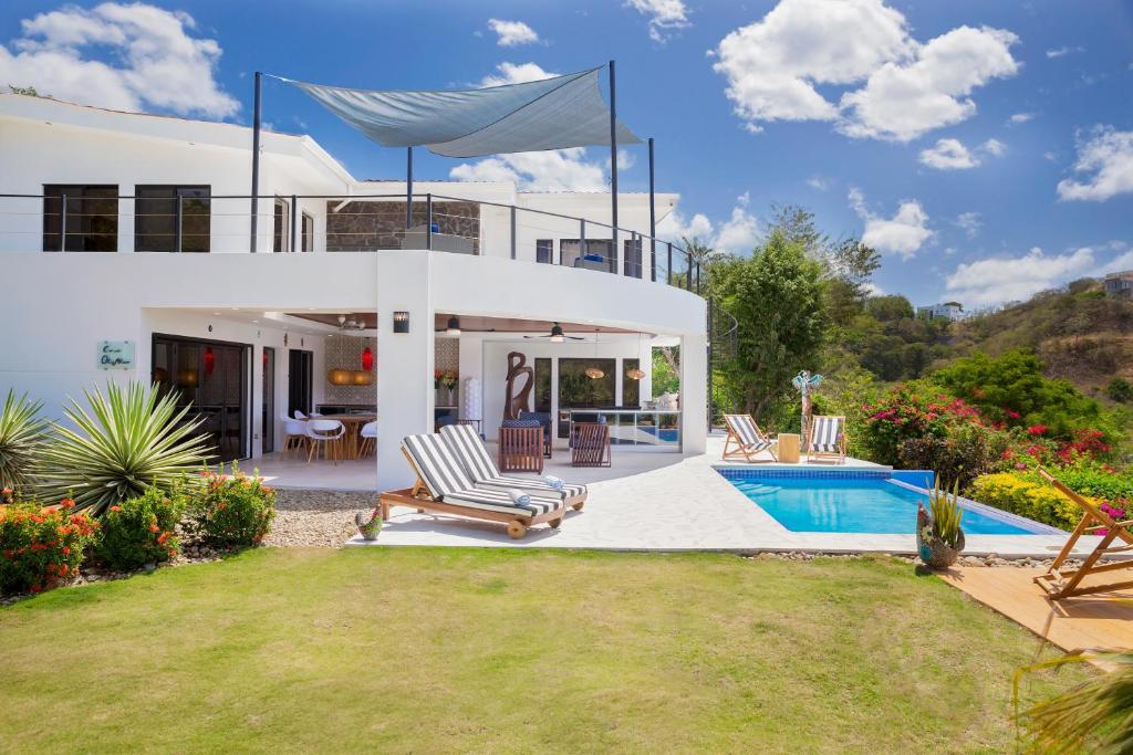 uma casa branca com uma piscina no quintal em Casa Oli Mar em San Juan del Sur
