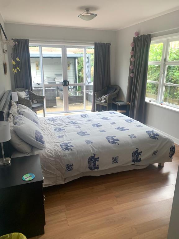 a bedroom with a bed with a blue and white comforter at Robert ST Newlands in Wellington