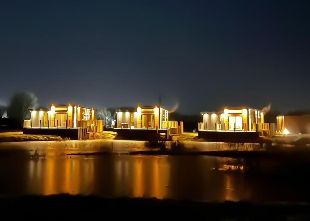 a group of buildings lit up at night at Hambleton Lakeside Lodges in Poulton le Fylde