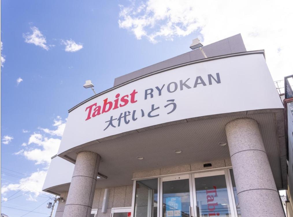 um edifício com um sinal que lê a elite ayushani mais rica em Tabist Tagajonoyado Ito em Tagajo