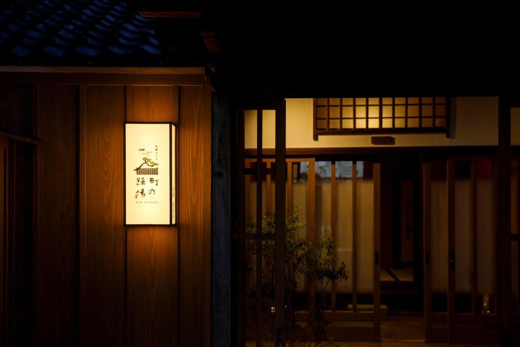 znak oświetlony na boku budynku w obiekcie Machi no Odoriba w mieście Kanazawa