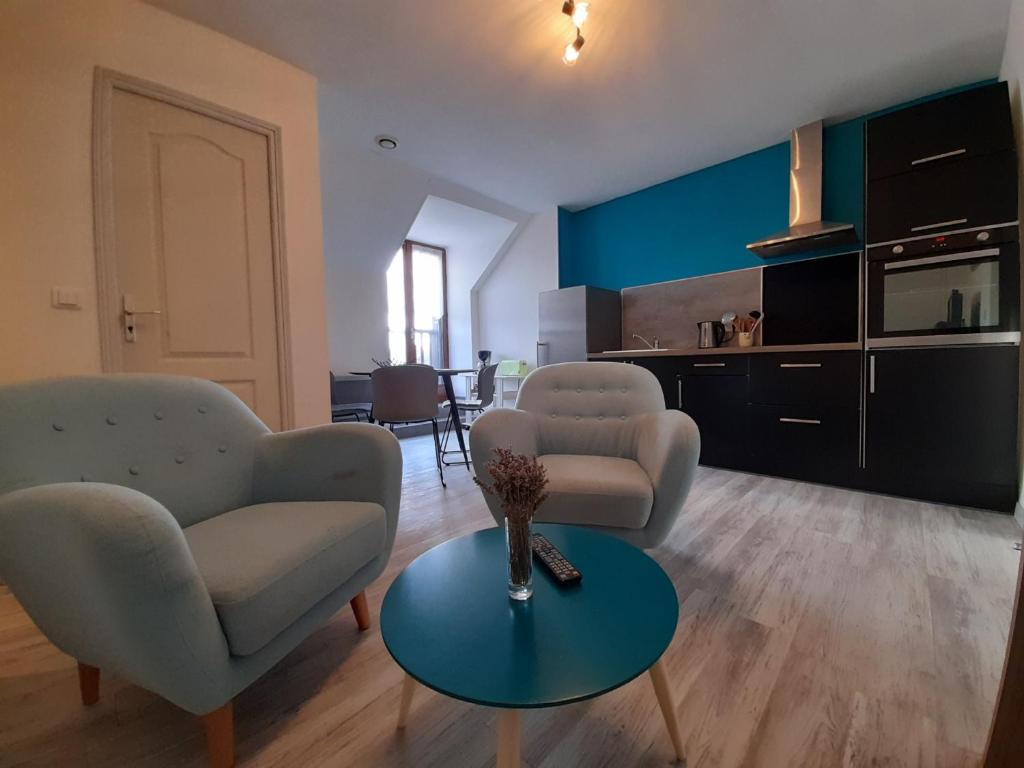 ein Wohnzimmer mit zwei Stühlen und einem Tisch in der Unterkunft Appartement 2 chambres avec Wi-Fi, proche centre-ville et thermes de La Roche-Posay - FR-1-541-10 in La Roche-Posay