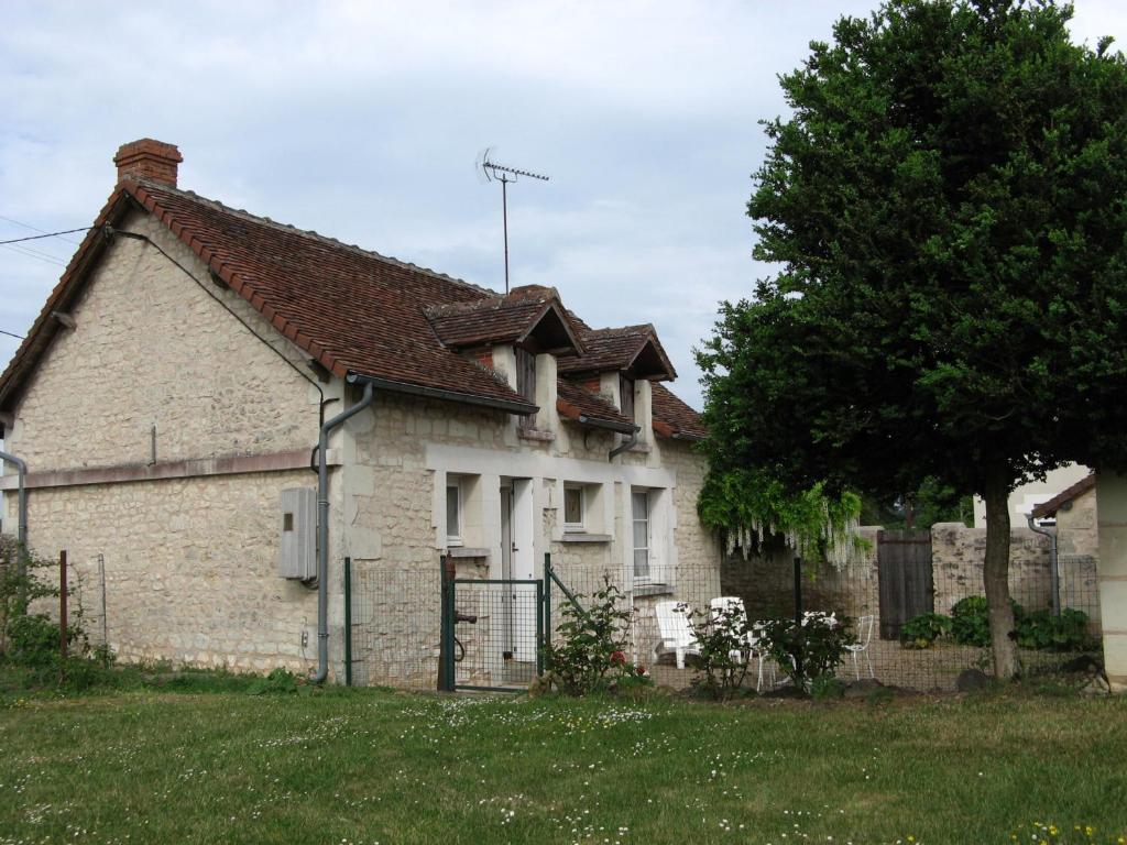 an old brick house with a tree in the yard at Maison Coussay-les-Bois, 3 pièces, 4 personnes - FR-1-541-38 in Coussay-les-Bois
