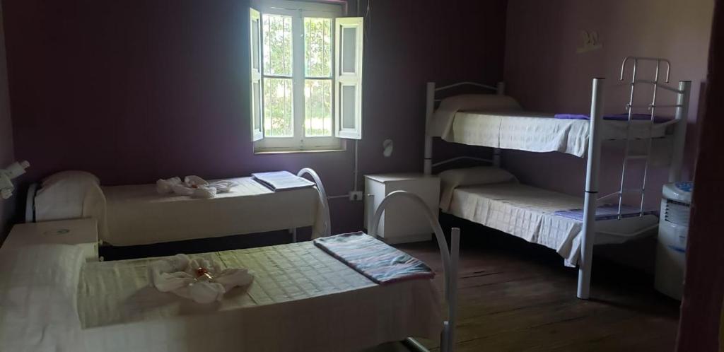 a room with three bunk beds and a window at El Trébol Casa de Campo in Naicó