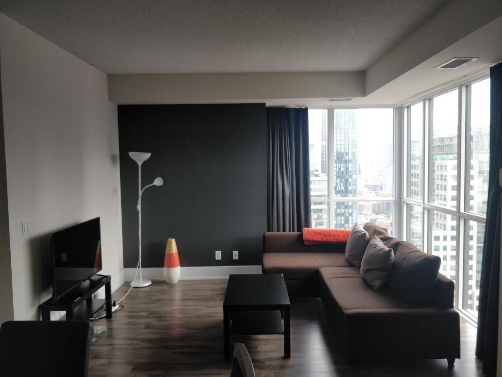 a living room with a couch and a large window at Entertainment District, Downtown Toronto - 300 Front 1 Bed 1 Bath, City View in Toronto