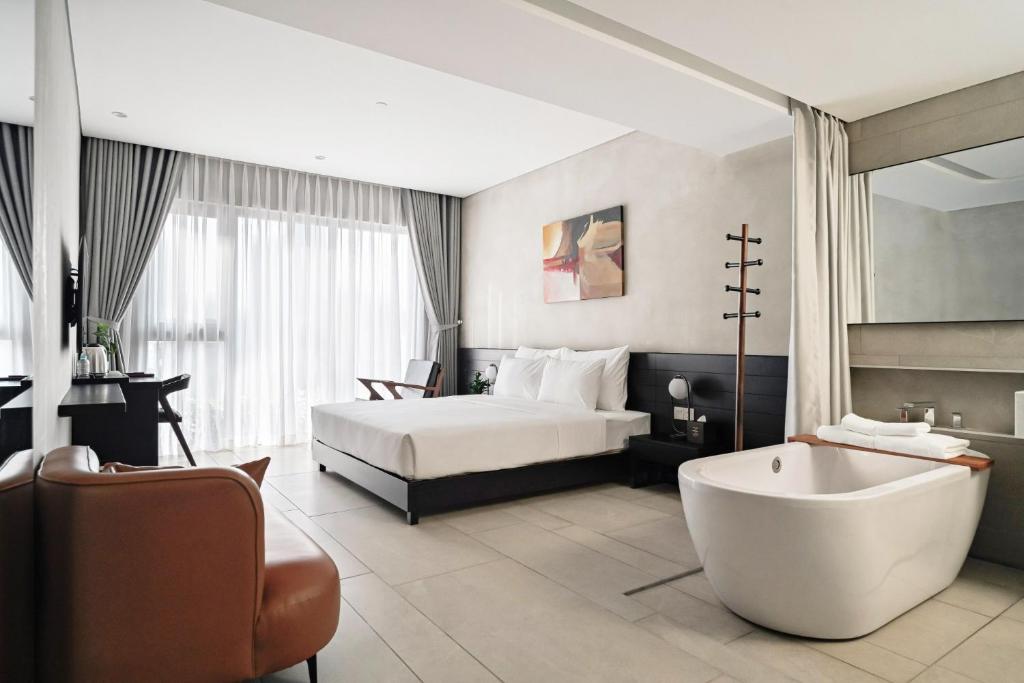 胡志明市的住宿－Triple E Hotel Metro Ben Thanh，酒店客房配有一张床和浴缸。