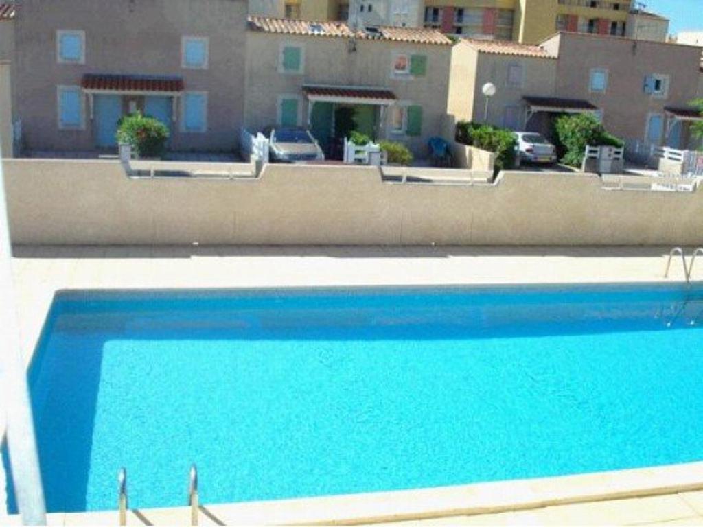 duży niebieski basen przed budynkiem w obiekcie Pavillon à Valras-Plage avec Piscine, à 250m de la Plage, pour 6 Personnes - FR-1-701-58 w mieście Valras-Plage
