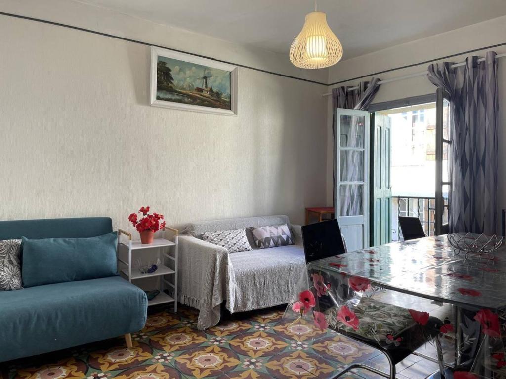 un salon avec un canapé bleu et une table en verre dans l'établissement Appartement Banyuls-sur-Mer, 3 pièces, 4 personnes - FR-1-225C-115, à Banyuls-sur-Mer