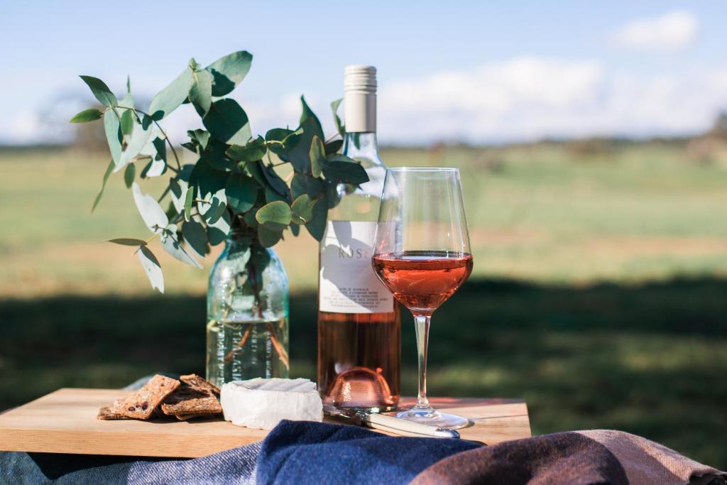 ein Glas Wein neben einer Flasche Wein in der Unterkunft Butmaroo Station in Bungendore