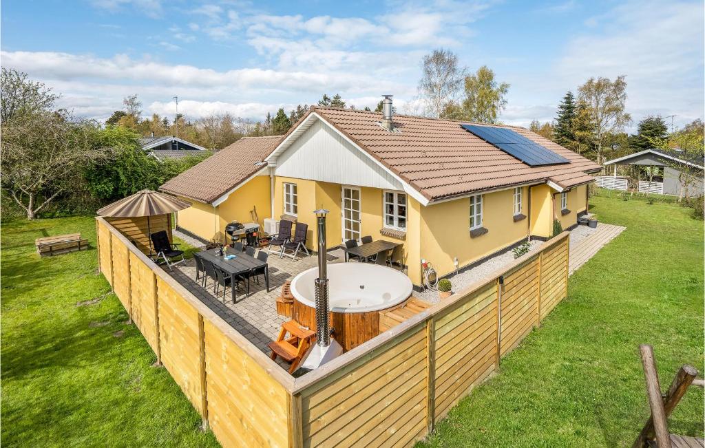 une maison avec un bain à remous sur une terrasse dans l'établissement Amazing Home In Glesborg With 4 Bedrooms, Sauna And Wifi, à Tvedhuse