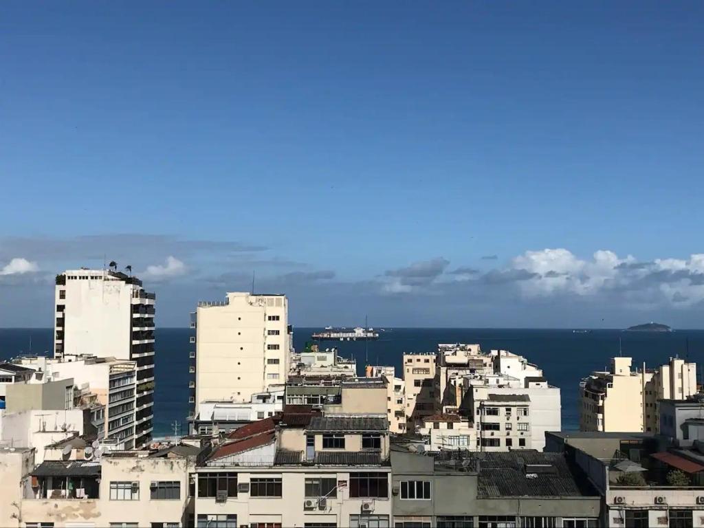 vistas a una ciudad con edificios y al océano en Apartamento com Suíte, varanda com vista total para o mar de Copacabana, garagem, piscina e sauna, en Río de Janeiro