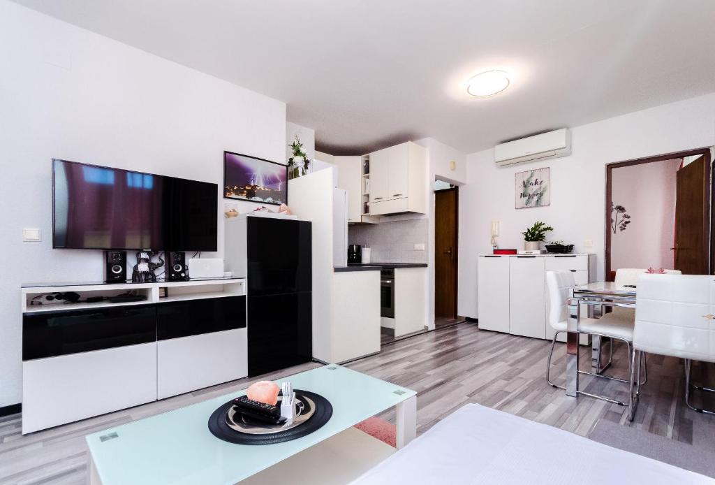 a kitchen with white cabinets and a table in a room at Apartment Mare in Vrsar