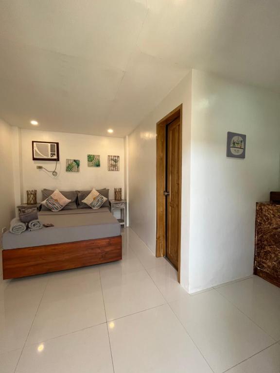 um quarto com uma cama e uma porta de madeira em Hutch Lodging House em El Nido