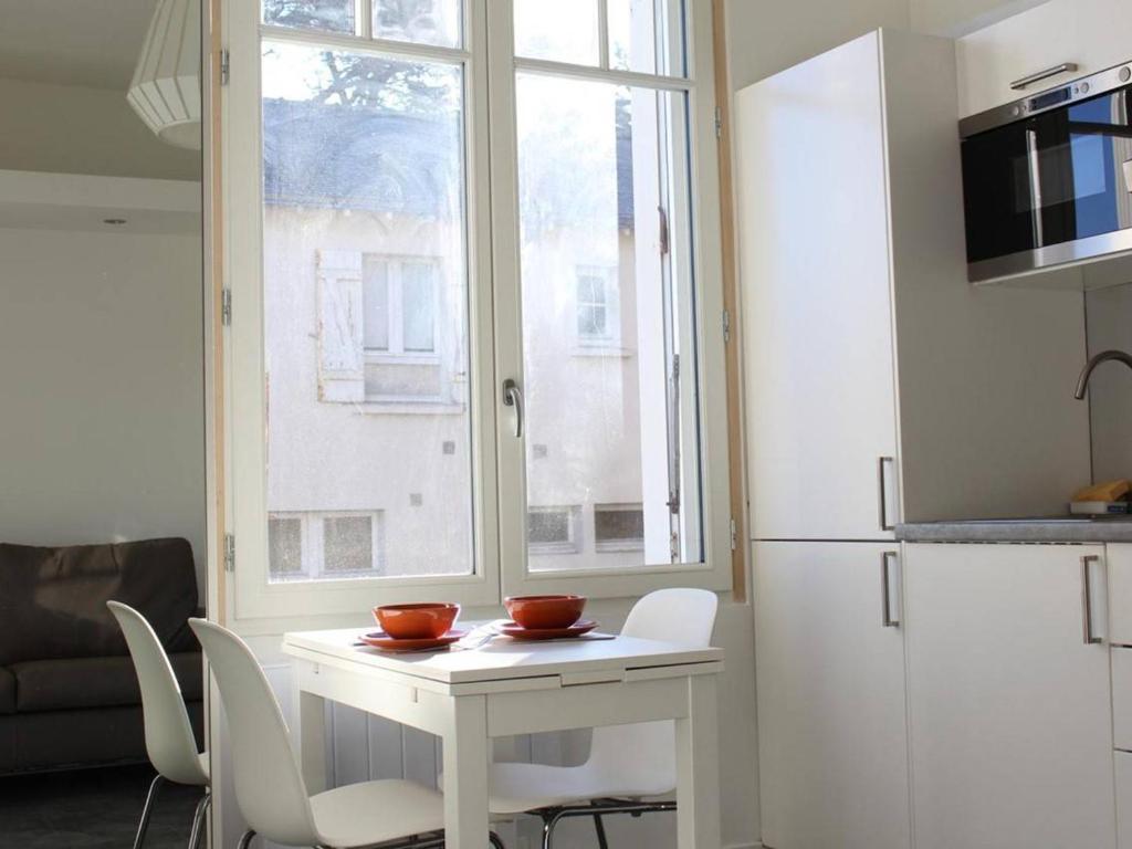 une cuisine avec une table blanche et une fenêtre dans l'établissement Charmant Studio Rénové, Idéalement Situé à La Baule, Proche Plage et Commodités - FR-1-245-86, à La Baule