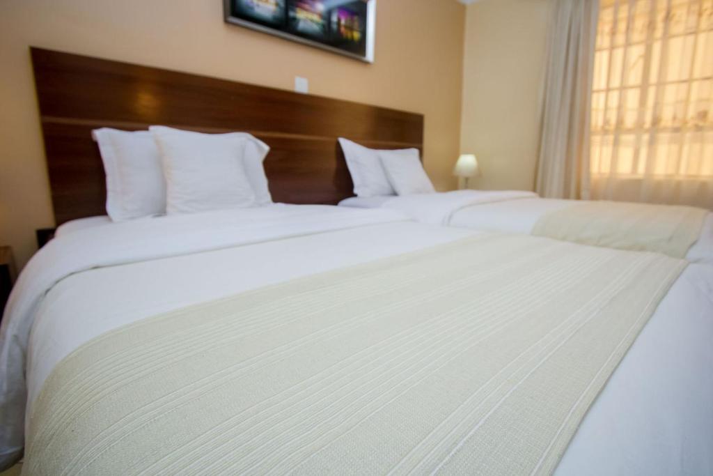 Postel nebo postele na pokoji v ubytování Capital Heights Hotel