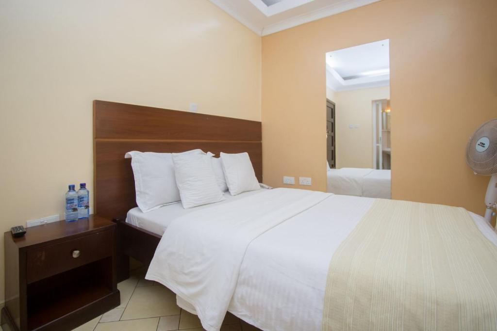 Postel nebo postele na pokoji v ubytování Capital Heights Hotel