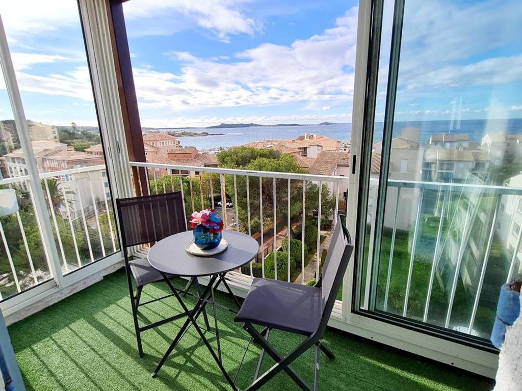 une table et deux chaises sur un balcon avec vue dans l'établissement T2 avec Wi-Fi, Parking Privé, Piscine et Tennis à 200m des Plages et Commerces - FR-1-316-259, à Six-Fours-les-Plages