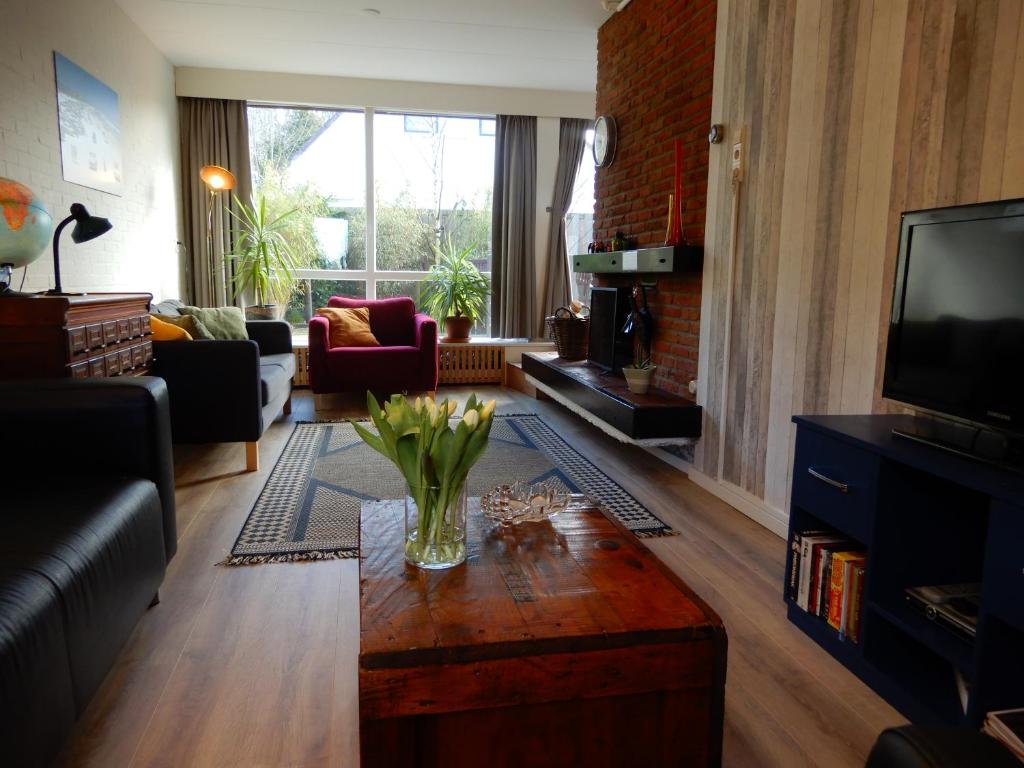 a living room with a vase of flowers on a coffee table at Holiday home Sunset in Noordwijkerhout