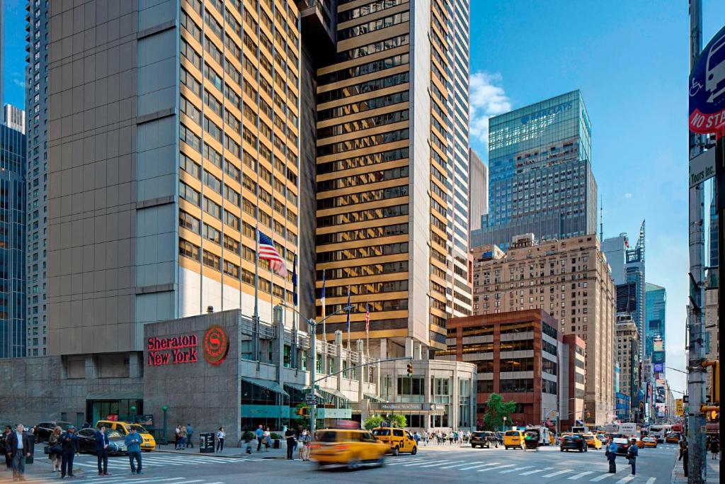 eine belebte Stadtstraße mit Autos, Menschen und Gebäuden in der Unterkunft Sheraton New York Times Square Hotel in New York