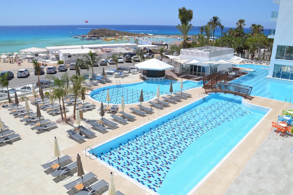 a beach filled with lots of blue umbrellas at Vassos Nissi Plage Hotel & Spa in Ayia Napa