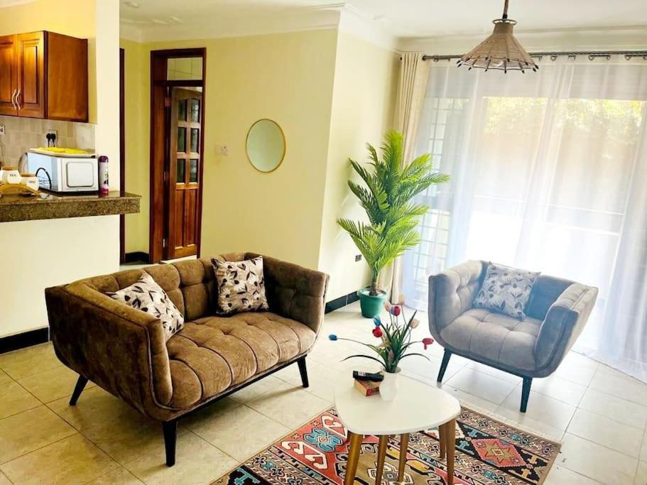 een woonkamer met een bank en een stoel bij Hyfram Homes - Peaceful, Quiet, very fast WI-FI in Kampala