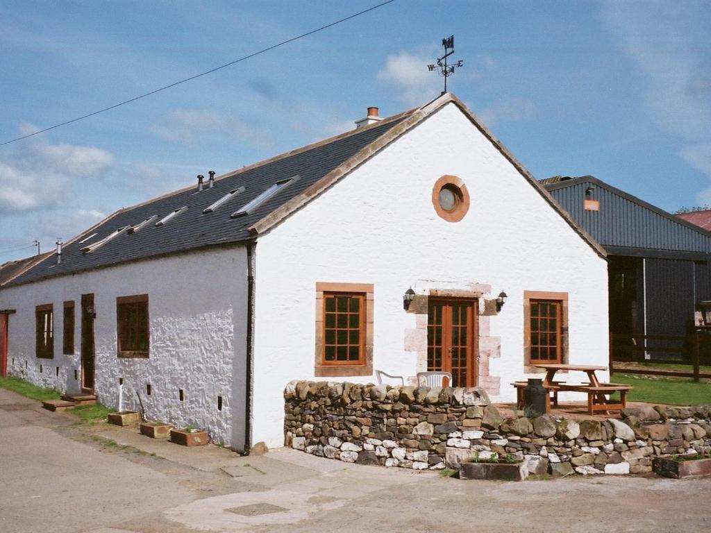 un edificio blanco con una pared de piedra en Beautiful Rural 3BR Cottage with Stunning Views, en Auldgirth