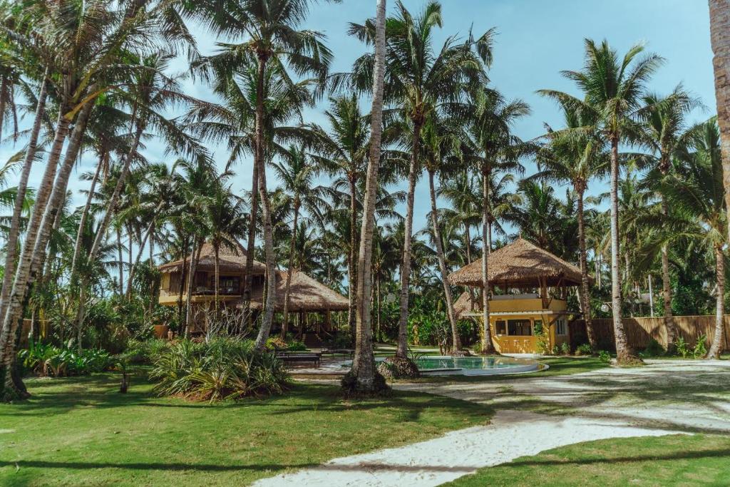 um resort com palmeiras e um edifício em INARA Siargao em General Luna