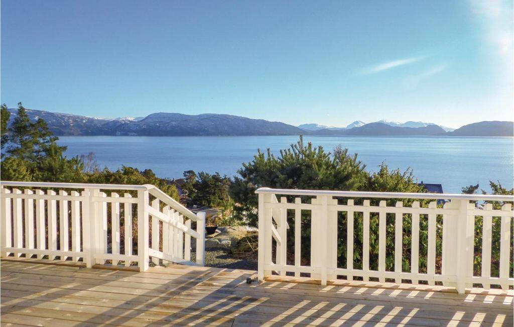 una valla blanca en una terraza con vistas al agua en Two-Bedroom Apartment In Strandvik, en Dalland
