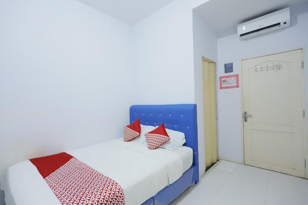 a bedroom with a blue bed with red pillows at OYO 92261 Aulia Homestay Syariah in Bagam