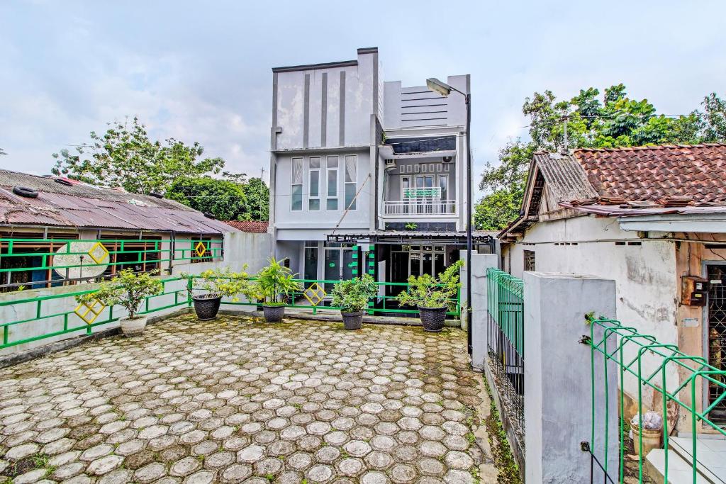 un edificio con macetas en un patio en Capital O 92250 Hall & Guesthouse Kowapi Syariah, en Purwokerto
