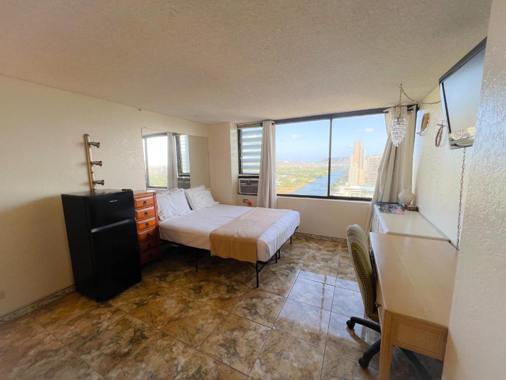 a bedroom with a bed and a large window at Hawaiian Monarch 2508 condo in Honolulu