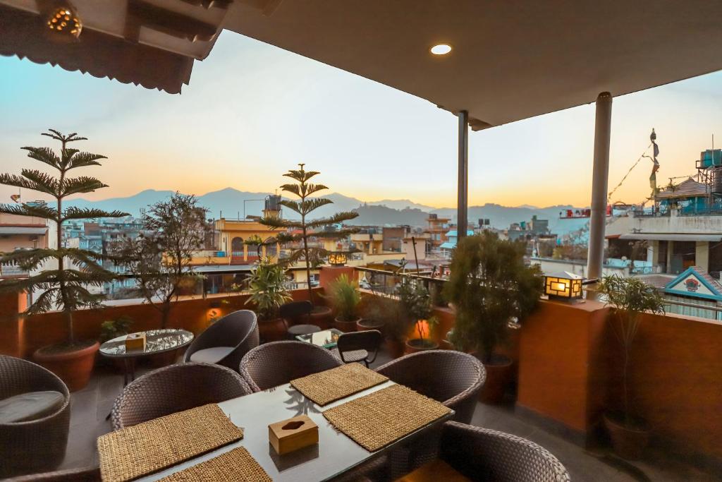 ein Restaurant mit Tischen und Stühlen auf einem Balkon in der Unterkunft Nivas Boutique Home in Kathmandu