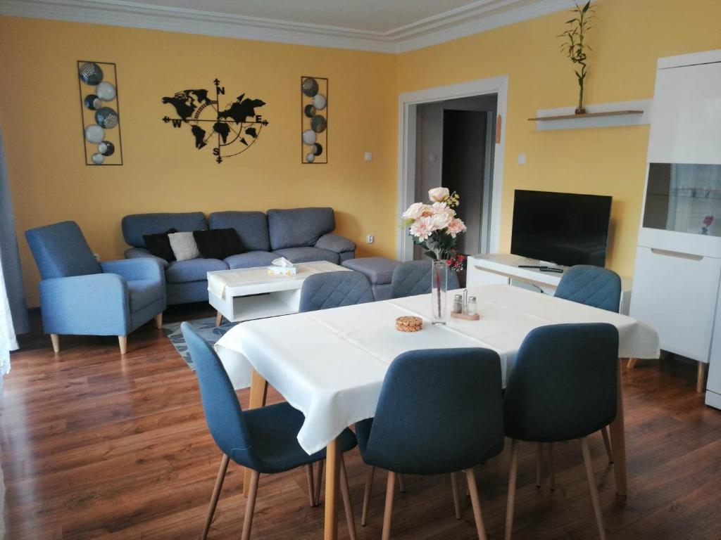 salon ze stołem i niebieskimi krzesłami w obiekcie Villa-Gallant w Popradzie